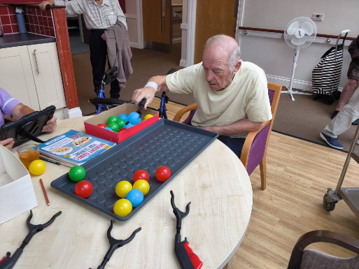 Resident playing Hungry Hippos at La Fontana Care Home